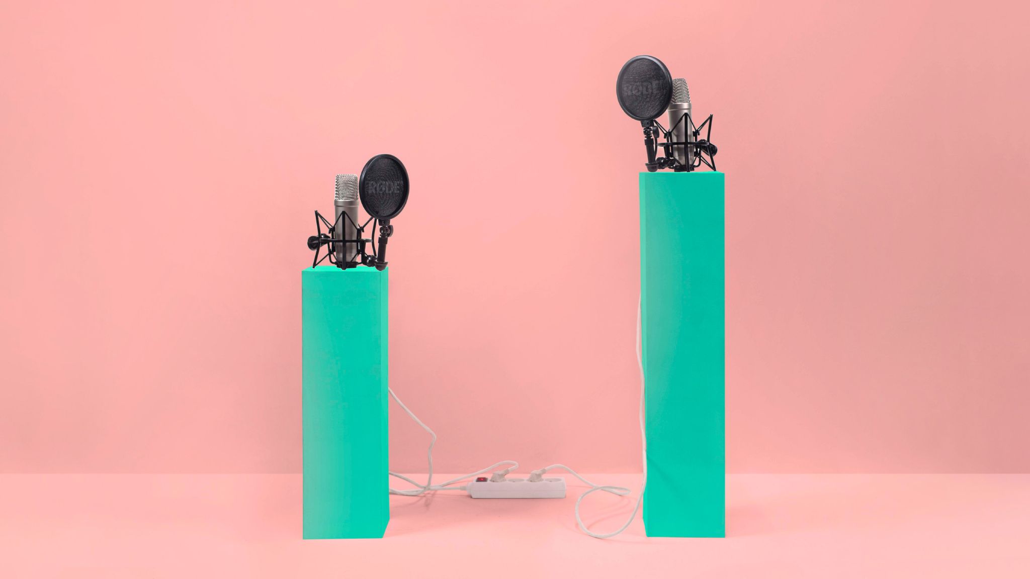 Two microphones on green stands against a pink background |Raynet CRM