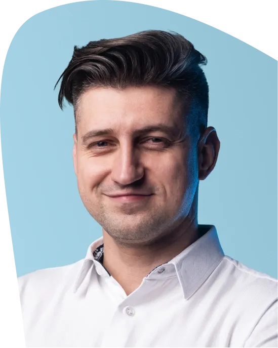 Professional headshot of a smiling man with dark hair in a white shirt.